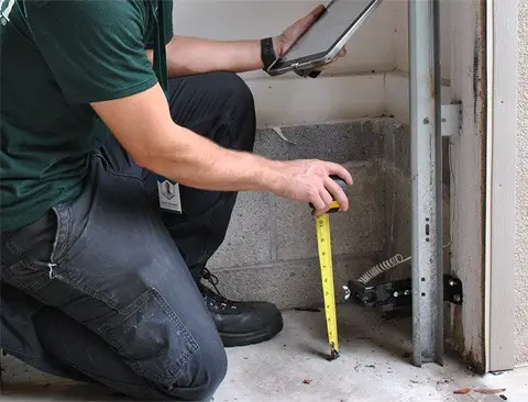 Precision Garage Door technician repairing a garage door